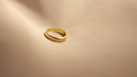 detalle del anillo de bodas de oro en la tela - cámara lenta