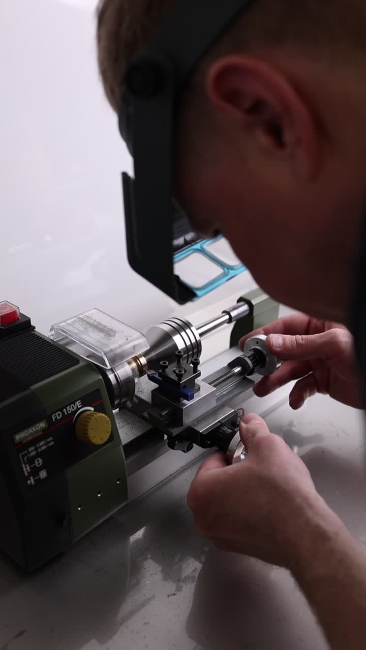 Man Operating a Small Precision Lathe Machine in a Workshop