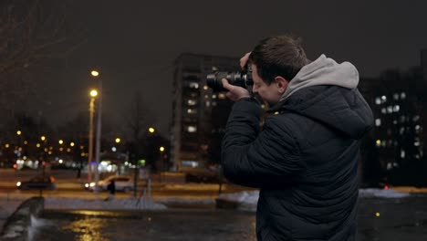 joven explorador urbano tomando fotos de escenas callejeras por la noche