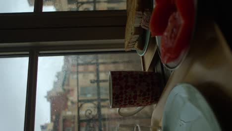 woman breakfast by the window with warm mug cup bread and tomatoes on the table vertical video
