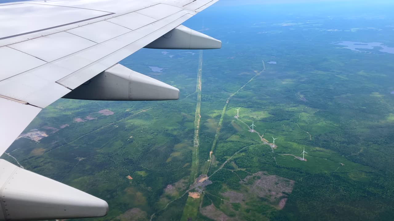 Wind turbines sustainable energy production from airplane window POV