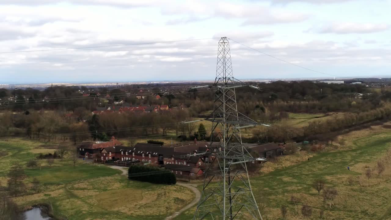 volando a través de la torre de distribución de energía eléctrica con vistas a la campiña británica