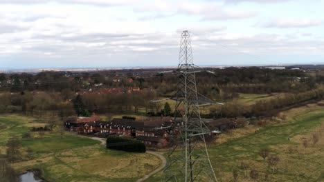 Flying-across-Electricity-distribution-power-pylon-overlooking-British-parkland-countryside