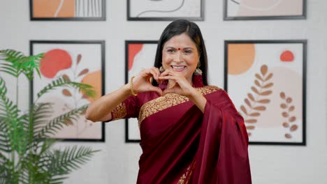 mujer india haciendo el signo del corazón