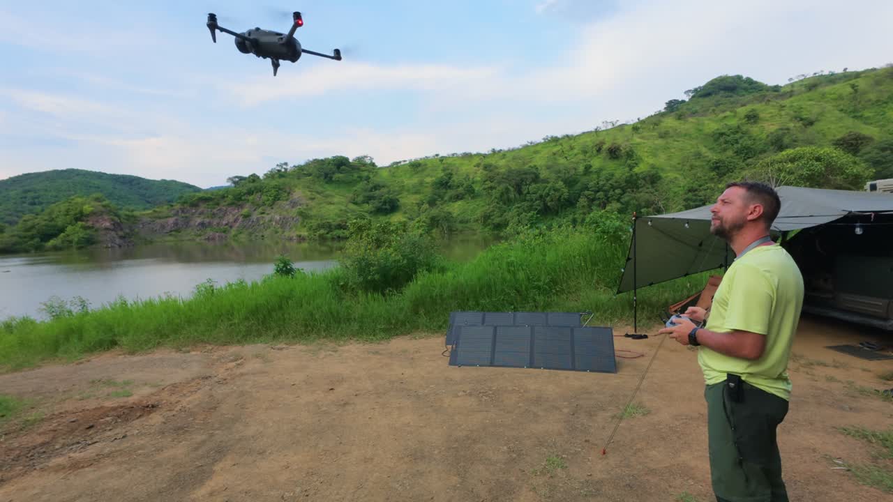 Pilota di drone con un drone in mano pronto al decollo. - Campo lungo