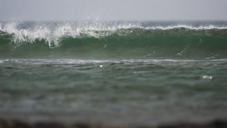 Wave-crashes,-curls-over-ocean-water,-the-coast-of-the-canary-islands