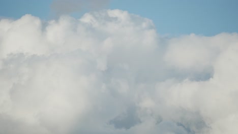 Timelapse-footage-of-fluffy-clouds-rushing-across-a-clear-blue-sky-on-a-sunny-day