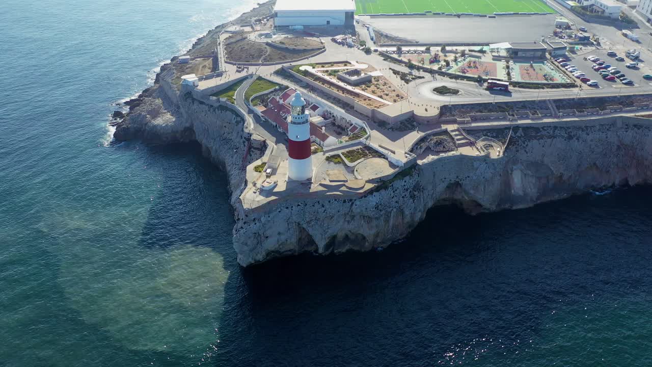 Stunning aerial footage captures the Cape St. Vincent Lighthouse perched on dramatic cliffs in Algarve, Portugal, overlooking the vast Atlantic Ocean. No people. Clear, vibrant, breathtaking