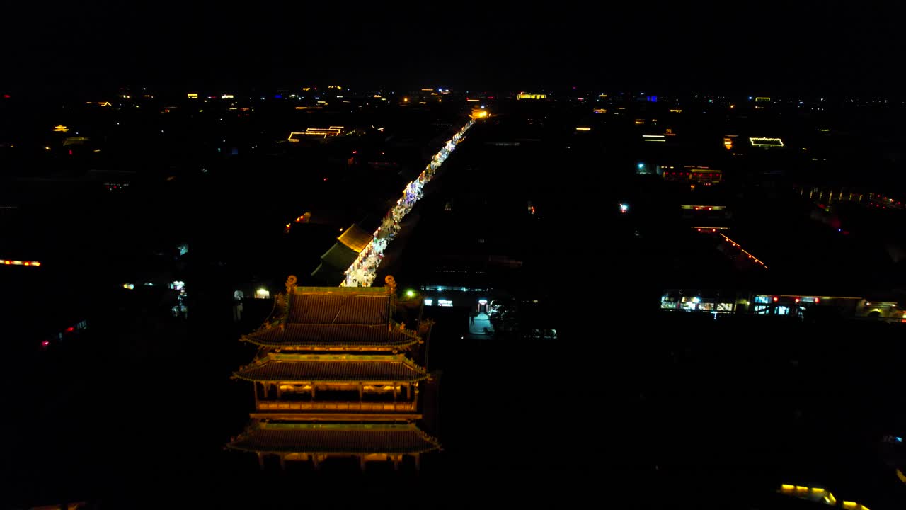 drone volando sobre la puerta sur de pingyao, ciudad antigua china por la noche