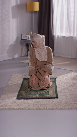 Vertical-Video-Of-Muslim-Woman-Wearing-Hijab-At-Home-Praying-Kneeling-On-Prayer-Mat-6