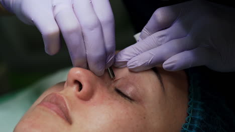 cosmetologist uses metal tools at work for skincare. pore cleansing in the salon. close up.