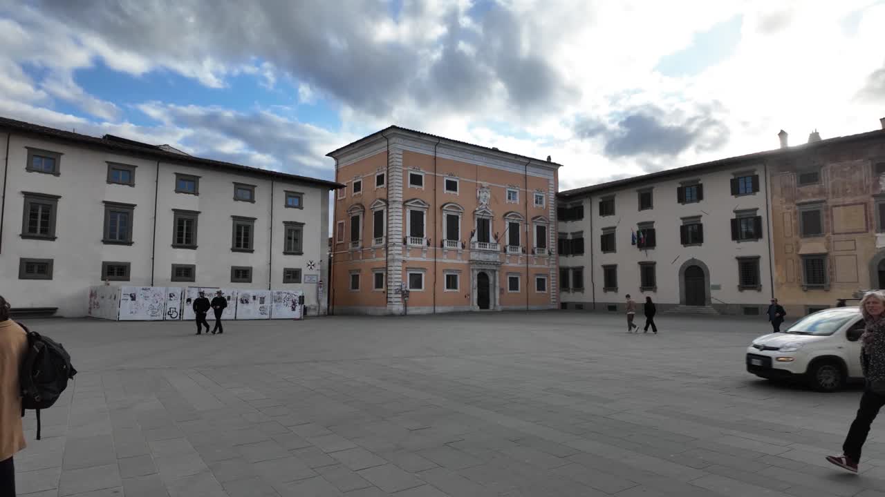 Lucca Italy old town city, group of people walk by paved square Italian