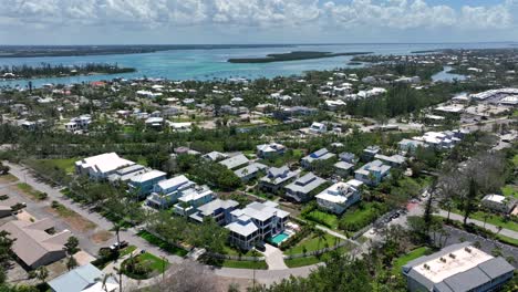 aerial view of coquina beach, featuring a picturesque coastal community with a mix of residential areas surrounded by lush greenery and waterways. the scene captures bright blue skies and serene water