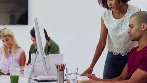 Executives-discussing-over-desktop-pc-at-desk-4k