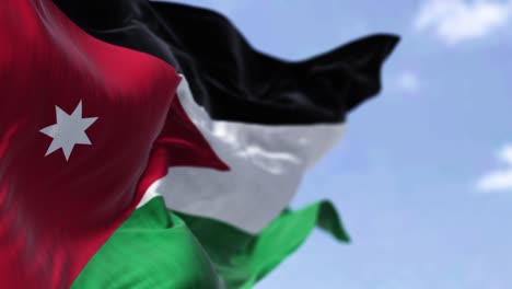 detail of the national flag of jordan waving in the wind on a clear day