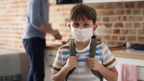 video portrait of schoolboy in protective face mask with backpack