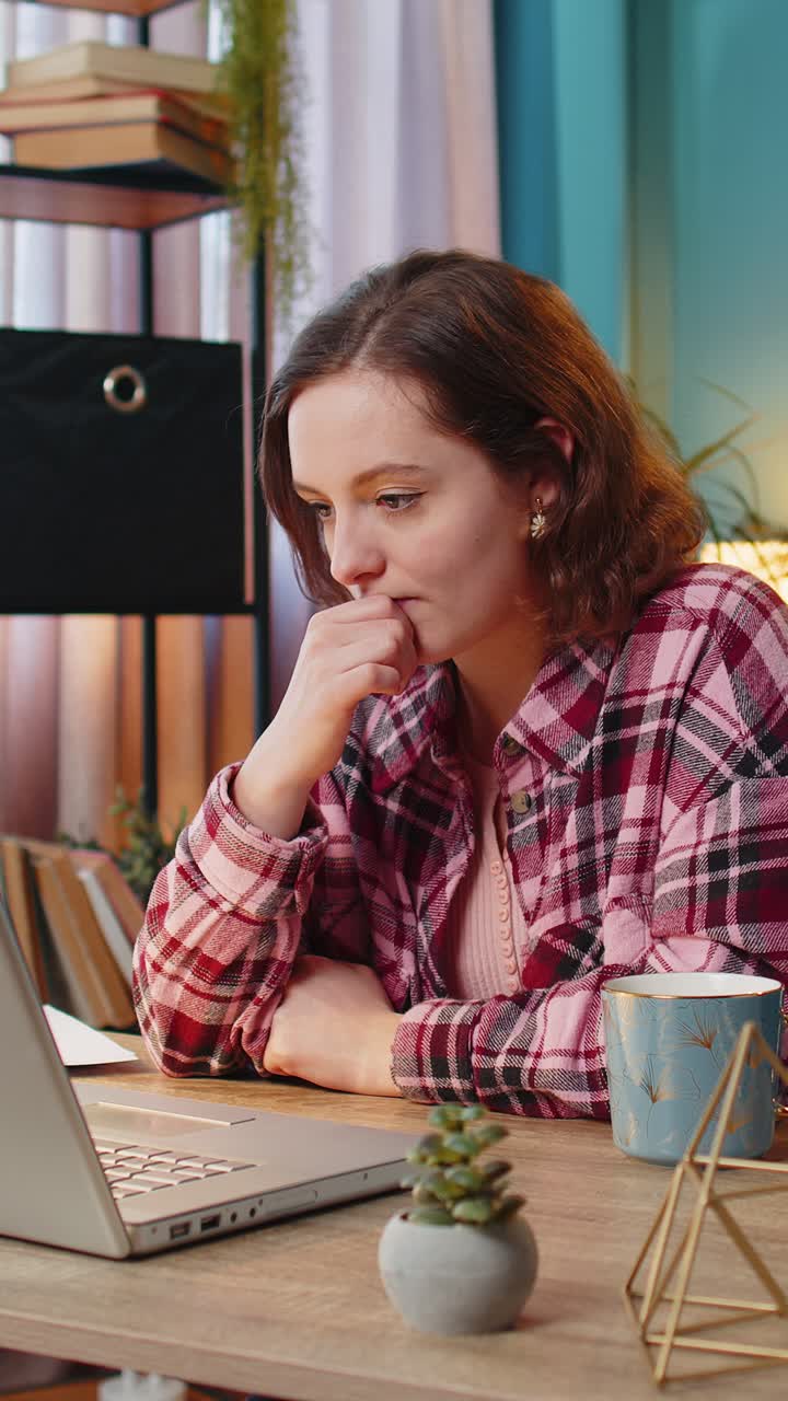 mujer de negocios trabajando en una computadora portátil bebiendo una taza de café caliente caliente sentada en la mesa en la oficina de casa