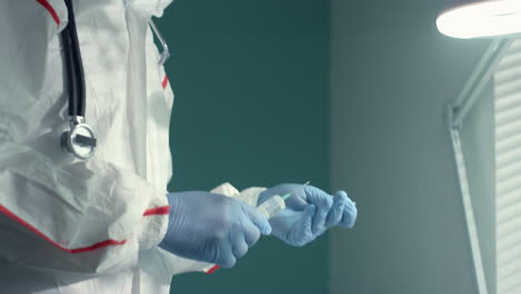 el médico prepara la jeringa de la vacuna en traje protector. campaña de atención médica antivirus