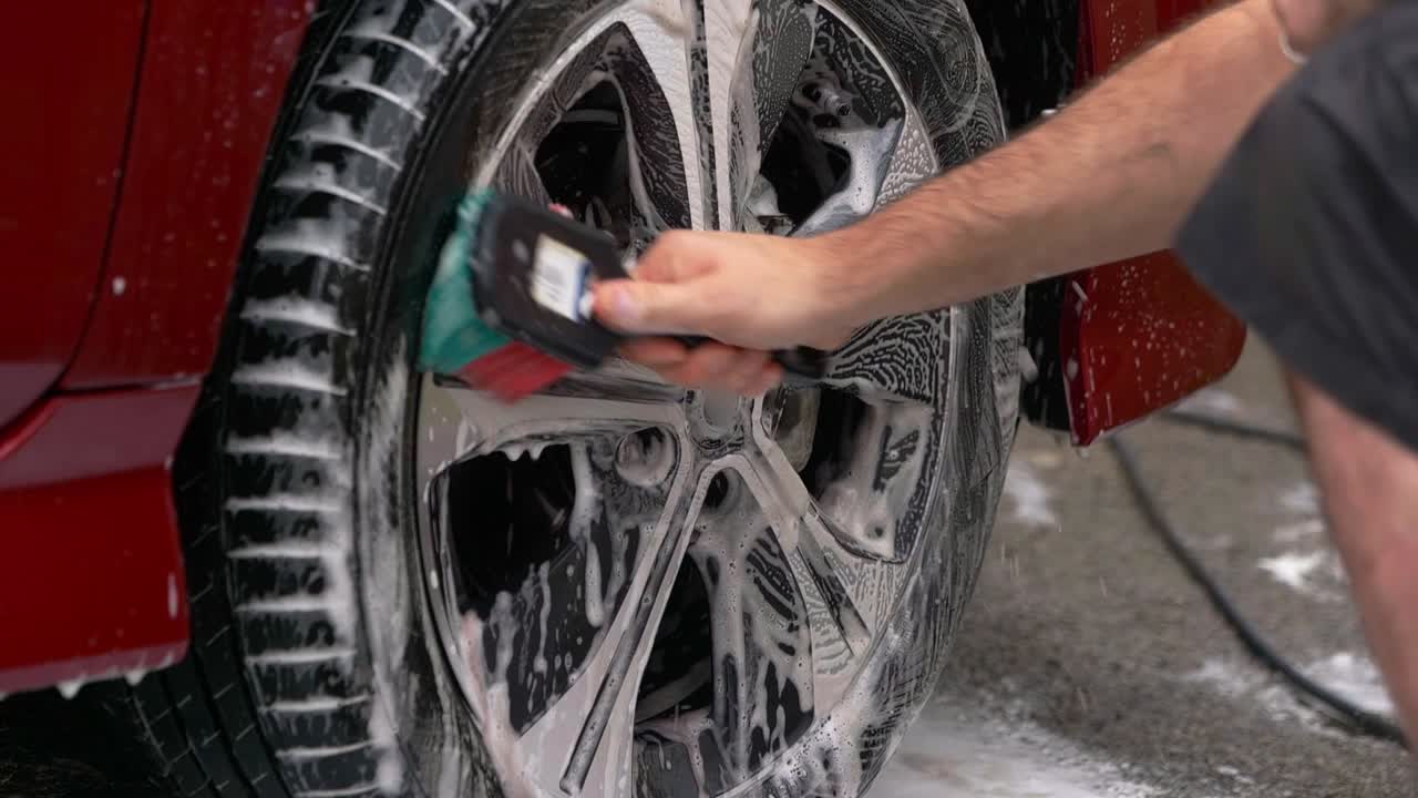Cleaning black and silver wheel faces with detailing brush, snow foam, and shampoo