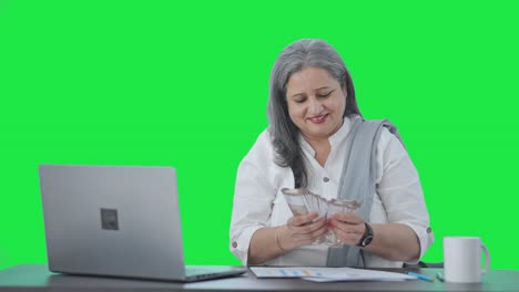 Cheerful-Indian-senior-businesswoman-counting-money-Green-screen