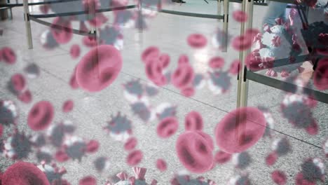 Animation-of-macro-Covid-19-and-blood-cells-floating-over-people-walking-at-airport