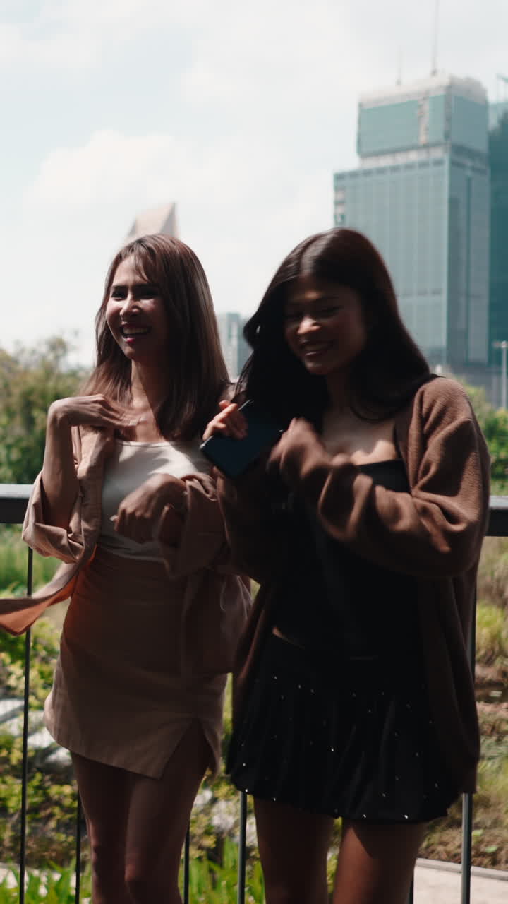 Jeunes femmes joyeuses dansant en extérieur avec un paysage urbain en arrière-plan