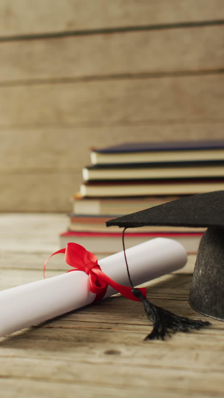 video vertical de un rollo de papel con cinta roja y una pila de libros en fondo de madera