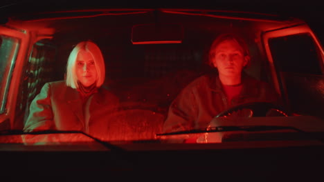 young couple sitting in car and posing for camera