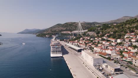 Dubrovnik-Port-Croatia,-showcasing-cruise-ship,-bridge,-coastal-town---Aerial