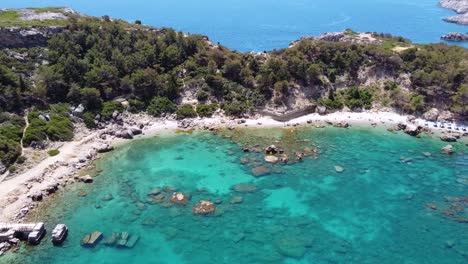 cinematic drone shot showing breathtaking beach in greece zooming out from the shore while seaguls passes by