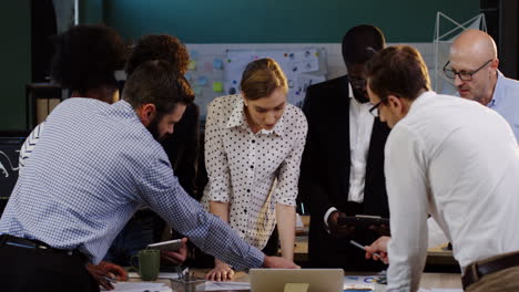 multiethnic business team analyzing documents, charts, financial reports and graphics in the office