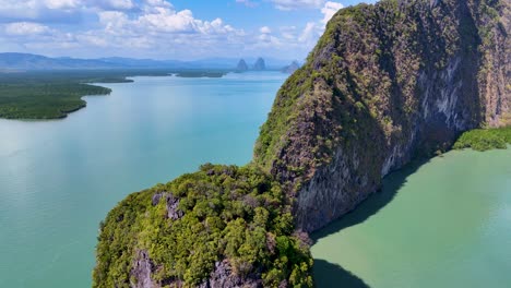 drone footage captures the stunning limestone cliffs and turquoise waters of phang nga bay, thailand, under bright sunlight