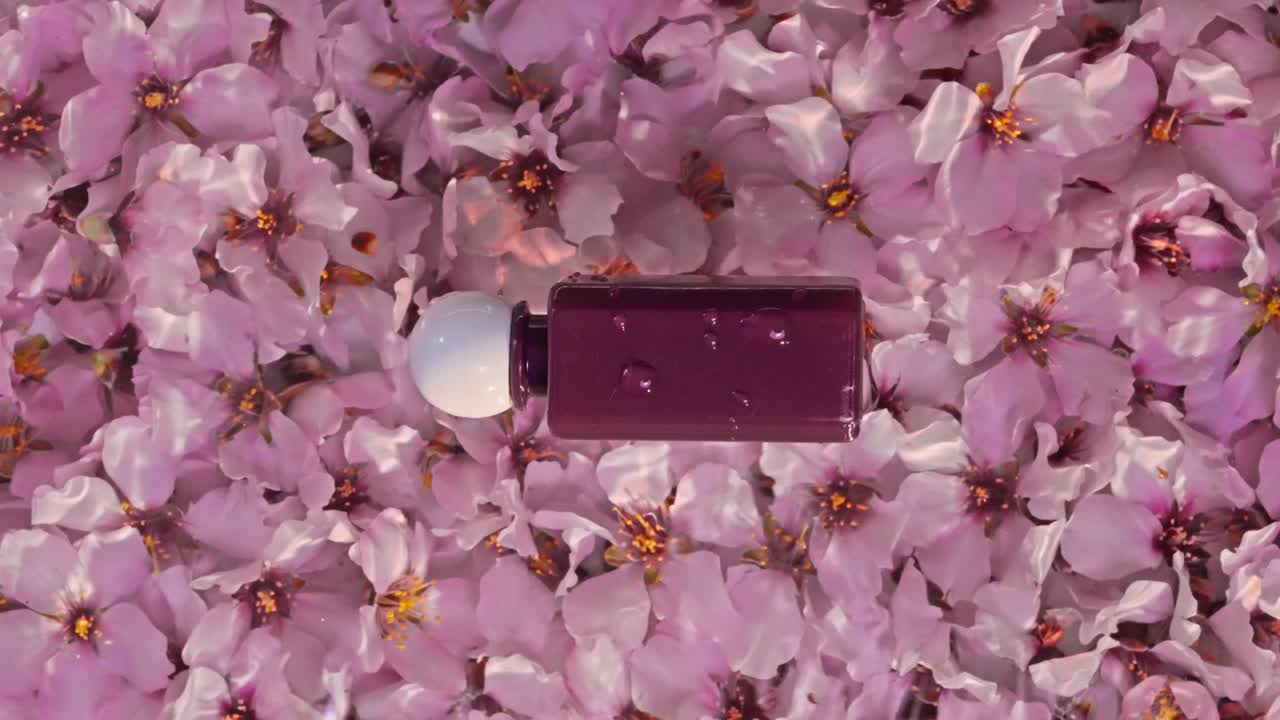 Confezioni cosmetiche su uno sfondo di fiori di mandorlo rosa, effetto onda d'acqua