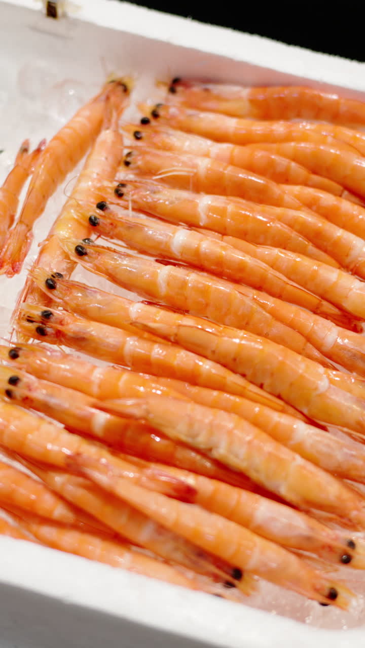 Close up of shrimp on ice on display at the Tsukiji Fish Market in Japan. Vertical