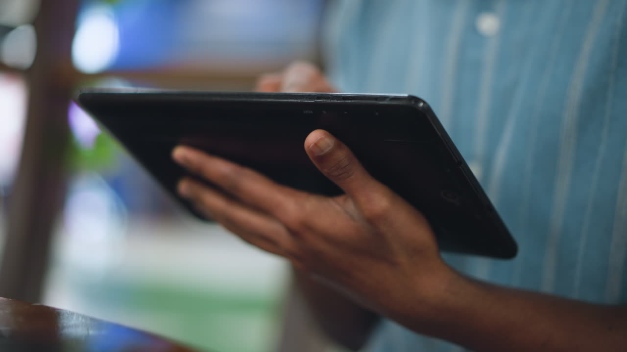 Warm rays of light beam through dusty room window onto hands gently cradling Ipad screen palms support device while golden glow creates serene interplay between technology and natural illumination