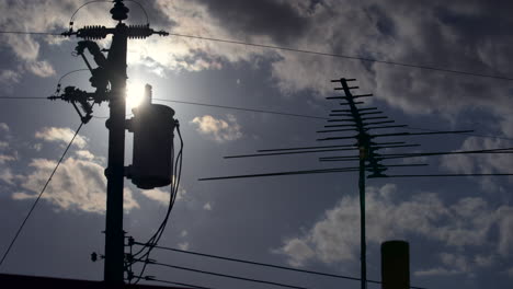 lapso de tiempo del sol poniéndose detrás de antenas de techo y líneas eléctricas
