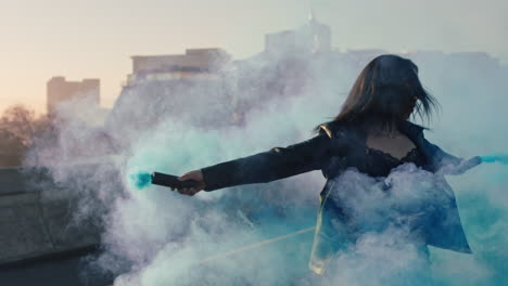 chica bailando con granada de humo azul en la ciudad joven mujer rebelde celebrando la expresión creativa con el baile en la calle en cámara lenta