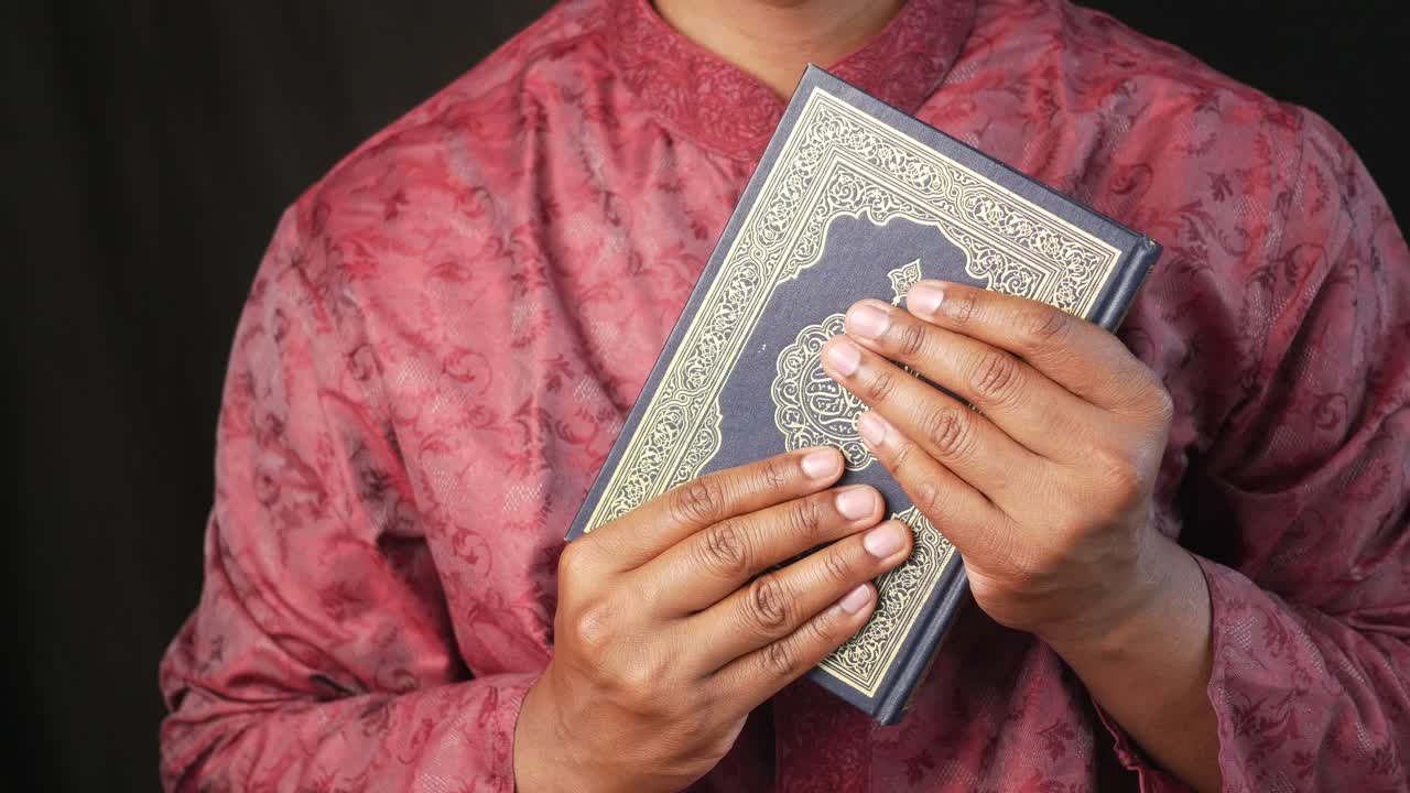 꾸란 을 들고 있는 무슬림 남자