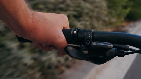 a hand holding the handlebar of a bicycle