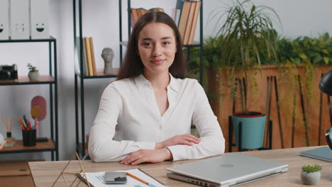 caucasian business woman sitting at office workplace desk closing laptop after finishing remote work