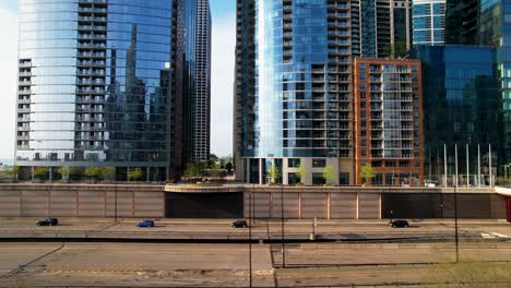 cars passing by luxury glass skyscrapers in downtown cityscape