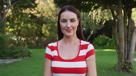 Portrait-of-happy-caucasian-woman-standing-in-garden-smiling-to-camera