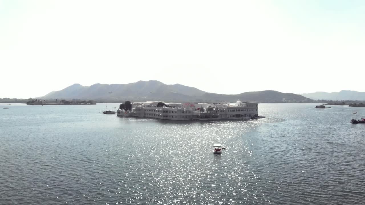 съемка с беспилотника в формате 4k прекрасного дворца тадж на озере пичола недалеко от города удайпур, индия