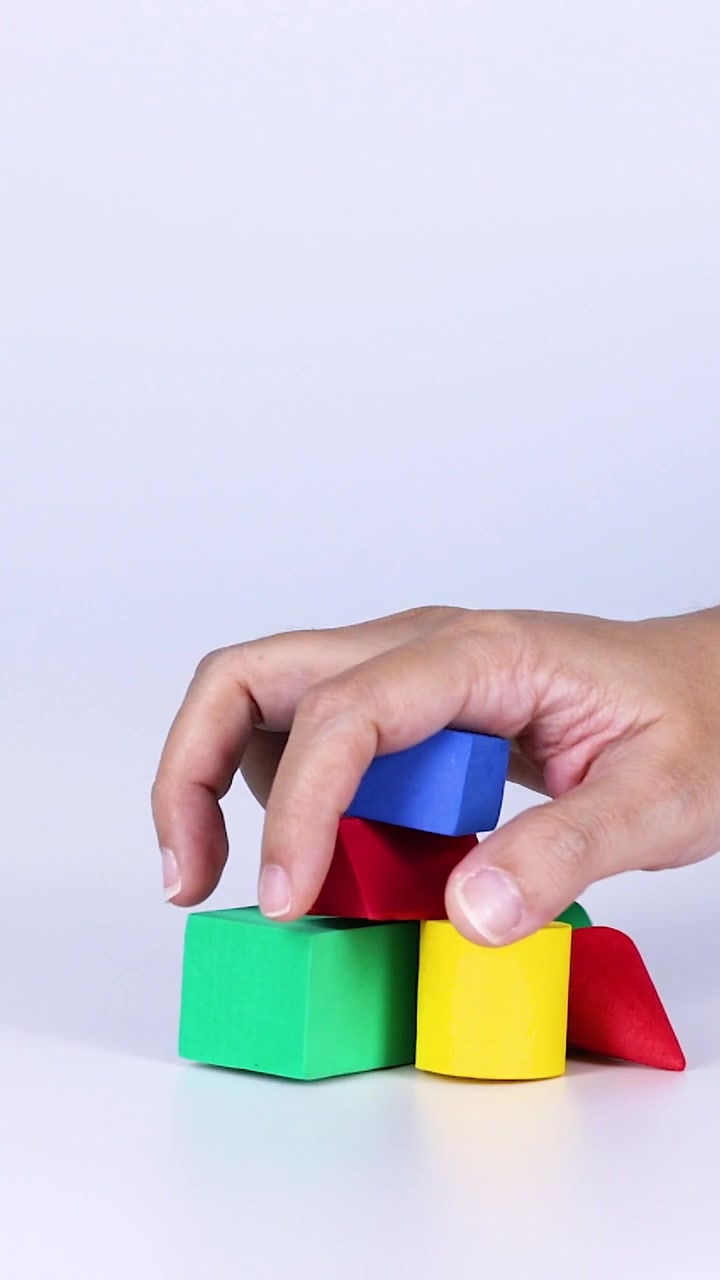 Manos organizando bloques coloridos sobre una superficie