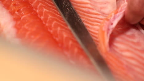 Itamae-Koch-Mit-Großartigen-Schneidfähigkeiten,-Der-Das-Fleisch-Eines-Lachsfisches-Für-Ein-Sushi-Gericht-In-Dünne-Scheiben-Schneidet