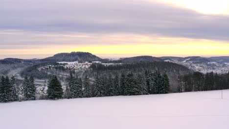 Amanecer-Sobre-Un-Paisaje-Invernal---Toma-Panorámica-Sobre-Un-Hermoso-Campo-Blanco-Nevado-Con-Colinas-En-El-Fondo