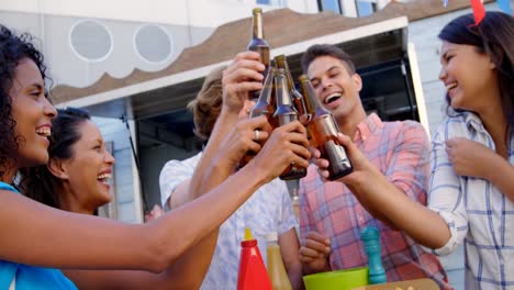 group of friends toasting beer bottles