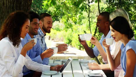 grupo de amigos brindando tazas de café en una cafetería al aire libre