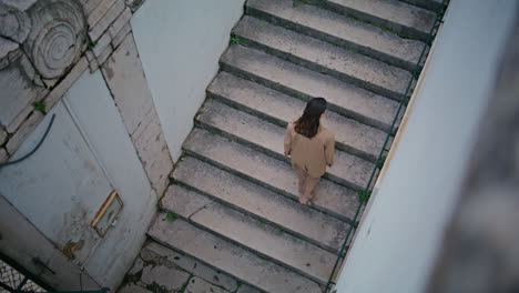 girl traveller going upstairs urban street in elegant suit alone. woman walking