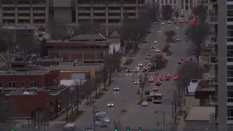 Cars-driving-down-the-street-on-a-winter